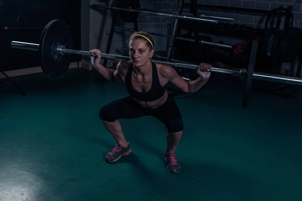 Crossfit Muscular mulher forte agachamento com peso pesado no ginásio — Fotografia de Stock