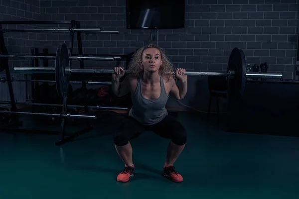 Poderosa atleta haciendo sentadillas con pesas pesadas. formación cruzada — Foto de Stock