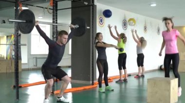Bir grup insan spor salonunda spor egzersizleri yapıyor.