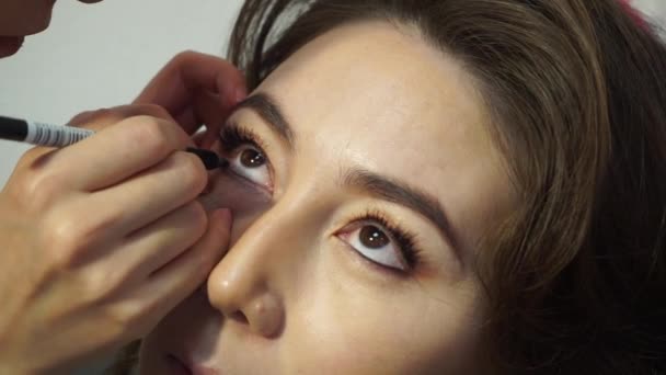 Maquillaje maestro pintar el interior de los ojos con lápiz negro. Maquillaje para la mujer kazaja — Vídeos de Stock