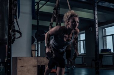 Güç egzersizleri. Bir kız sırt kasları spor salonunda bir egzersiz yapıyor