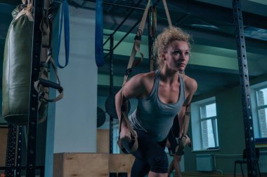 Güç egzersizleri. Bir kız sırt kasları spor salonunda bir egzersiz yapıyor