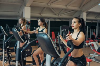 Spor salonunda bir koşu bandı üzerinde tren genç kızlar