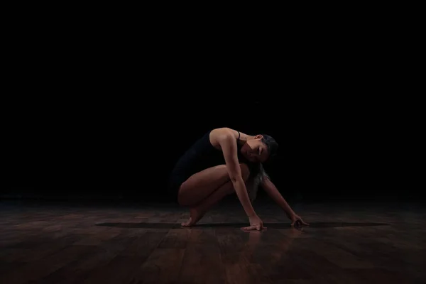 Flexible girl doing a gymnastic exercise on a black background. Sport. Fitness. Stretching. — Stock Photo, Image