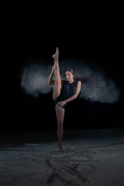 La ginnasta ragazza fa uno schizzo ginnico con polvere volante. Sport. Danza . — Foto Stock