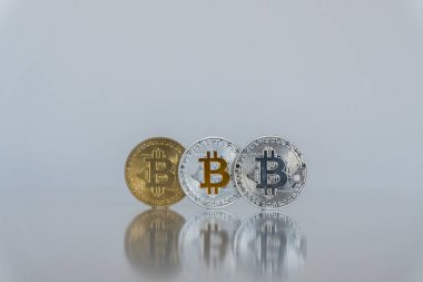 Bitcoins kümesi. Hafif bir arka plan üzerinde izole platin, altın ve gümüş sikke