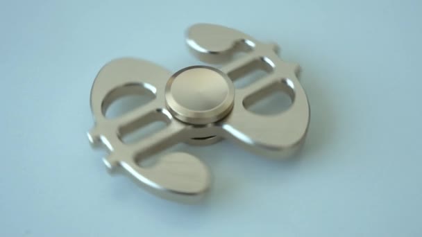 En leksak spinner ser ut som en dollar som långsamt snurrar på en ljus yta — Stockvideo