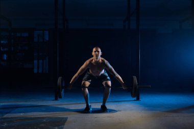 Güçlü adam spor salonunda bir halter kaldırma.