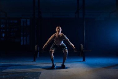 Güçlü adam spor salonunda bir halter kaldırma.