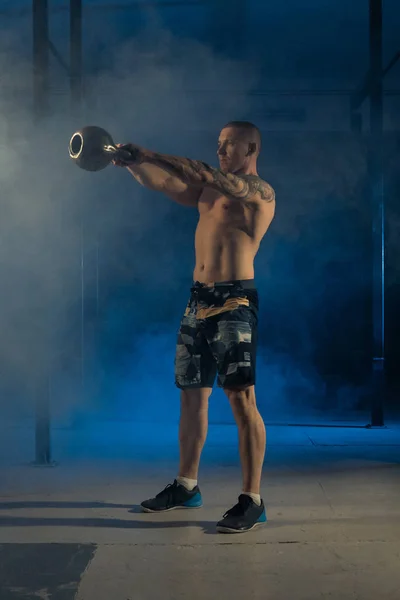 En stark man kastar vikt i luften i gymmet. Sund livsföring — Stockfoto