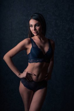 Karanlık bir arka plan üzerinde poz karanlık dantel iç çamaşırı cinsel cazibe esmer