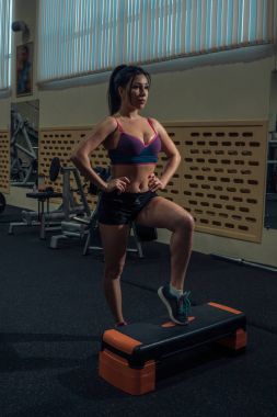 Kardiyo egzersizi. Genç kadın platform için bir step aerobik egzersizleri yapıyor