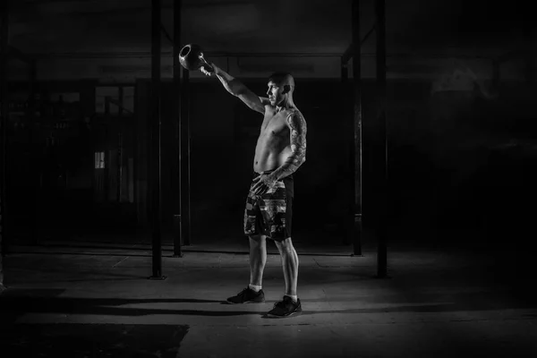 Muskulös manliga idrottare drar vikt i filtret gym svart och vitt — Stockfoto