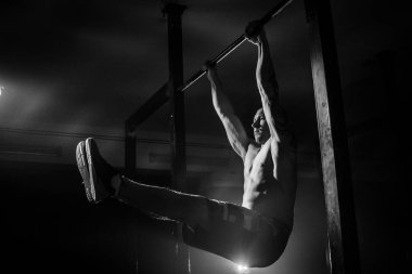 Adam pull-up çubuk üzerinde yapar. Siyah ve beyaz