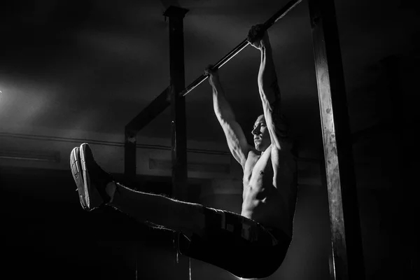 El hombre hace flexiones en el travesaño. Blanco y negro — Foto de Stock