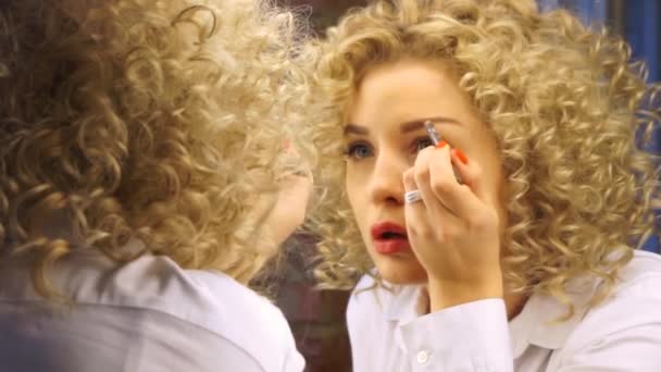 Portret van een mooi meisje die make-up zelf doet. — Stockvideo