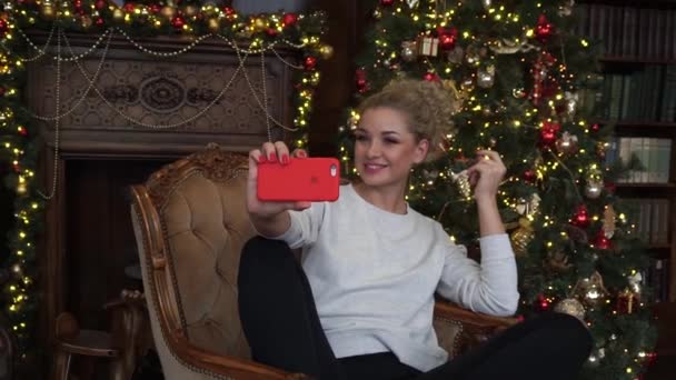 Chica haciendo selfie en casa en Navidad y riendo — Vídeos de Stock