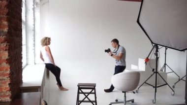 Genç manken stüdyo için pencere yakınındaki bir fotoğraf fotoğrafçı çeker