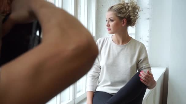 Modello professionale posa guardando fuori dalla finestra, poi sulla macchina fotografica — Video Stock