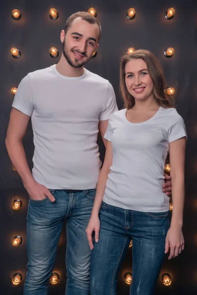 一个女孩和一个男孩模特穿着白色衬衫和蓝色牛仔裤在演播室 — 图库照片