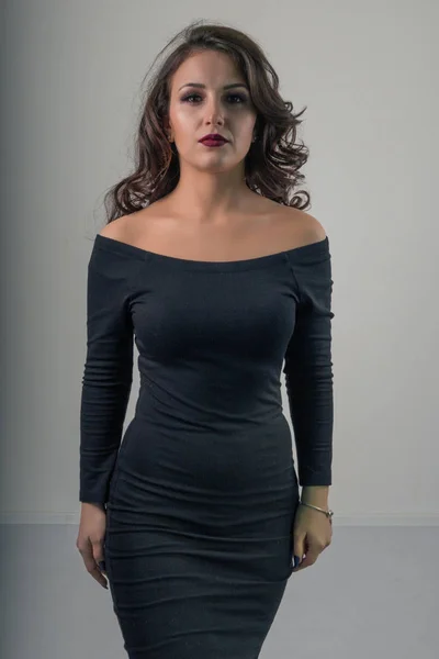 Portrét okouzlující krásné dívky v černém sexy šaty na světlém pozadí — Stock fotografie