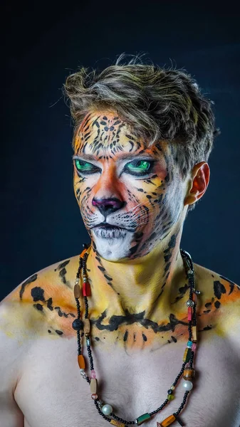 Mannen med en tiger ansikte konst på en mörk bakgrund — Stockfoto