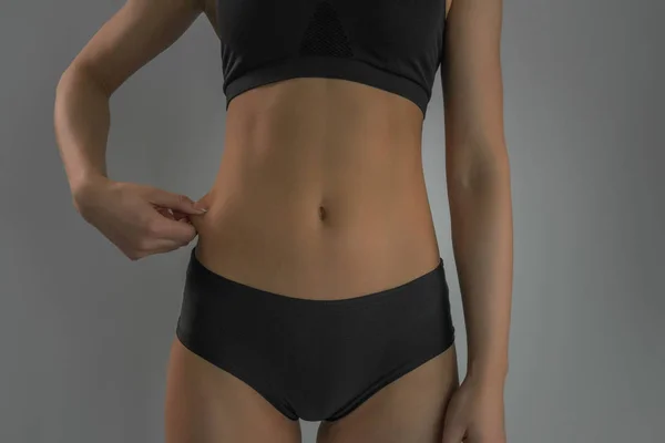 Sexy sportlich fit weibliche Figur Nahaufnahme auf grauem Hintergrund . — Stockfoto