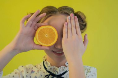 Güzel genç kız komik yüzü el ve sulu turuncu sarı bir arka plan üzerinde kapsar
