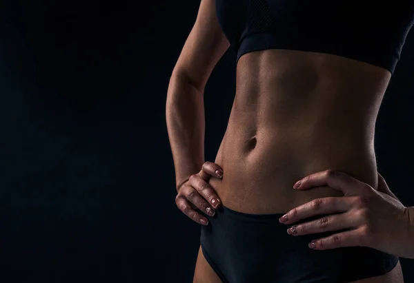 Slim female waist close-up. The female body in sport underwear.