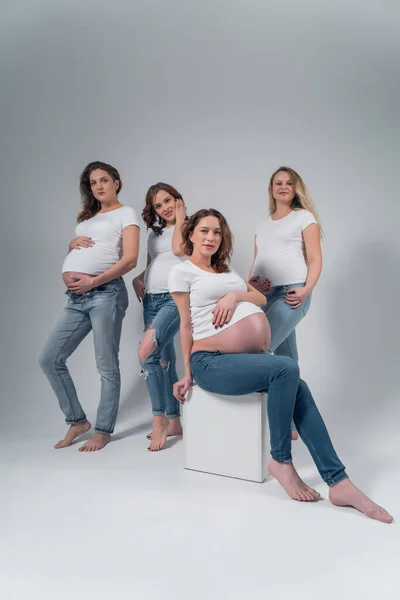 Quatro lindas meninas grávidas no estúdio . — Fotografia de Stock