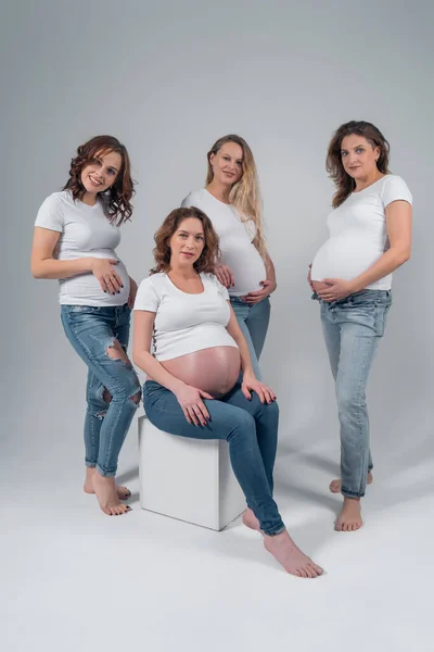 Quatro lindas meninas grávidas no estúdio . — Fotografia de Stock