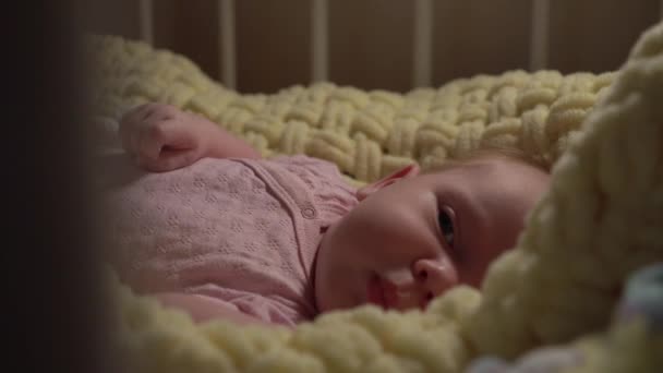 Close-up van een liegende baby in een wieg met open ogen — Stockvideo