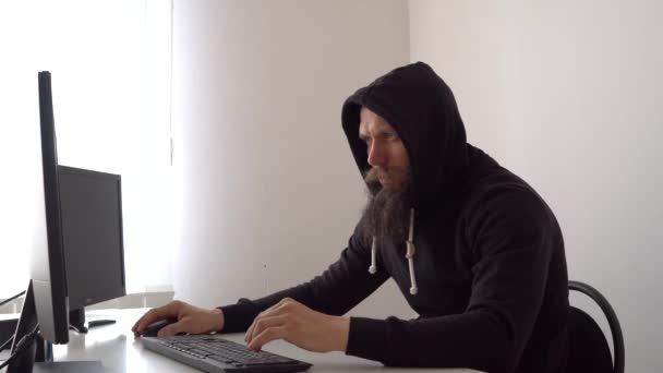 Hooded cybercriminelen stelen geheimen van een computer. — Stockvideo