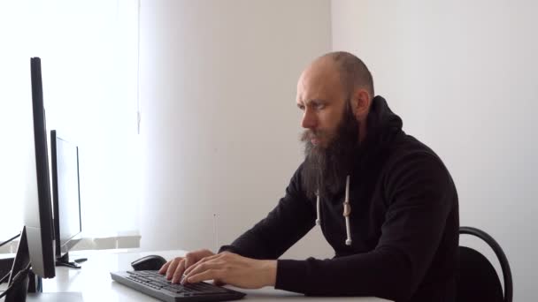 Bald bearded man working on computer — Stock Video