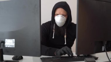 Kapüşonlu bilgisayar korsanı bilgisayarla bilgi çalıyor