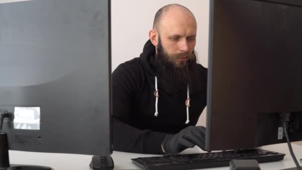 Hombre barbudo con guantes negros imprime el texto en el teclado — Vídeo de stock