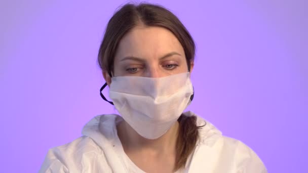 Handsome arts in beschermende overalls draagt drie maskers en glazen gezicht. — Stockvideo