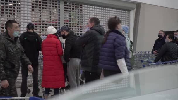 Kostanay, Kazachstán - duben,2020. Lidé čekají na otevření supermarketu. Skupina lidí v obchodě během pandemie. — Stock video