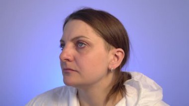 Mavi arka planda dans eden koruyucu kıyafetli genç bir kadın..