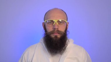 Sakallı beyaz adam gözlük ve beyaz kulaklık takıyor ve kafasını müziğe göre hareket ettiriyor..