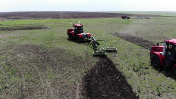Velký červený traktor orat zemi v slunečném počasí. — Stock video