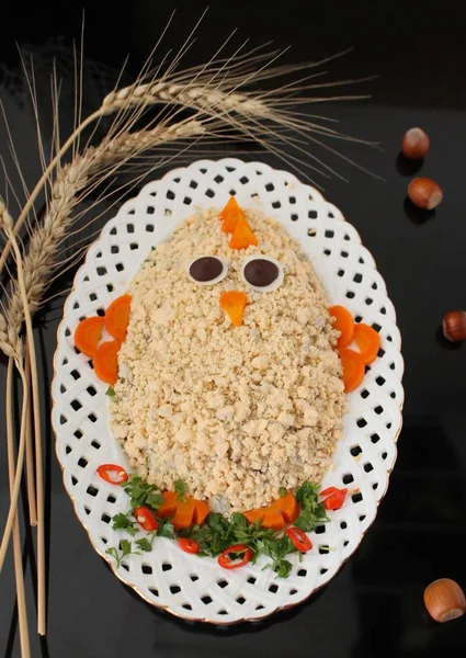 Easter salad. Creative food art idea on Easter meal party for children. Thematic Easter snack shaped funny chick decorated egg yolk and vegetables
