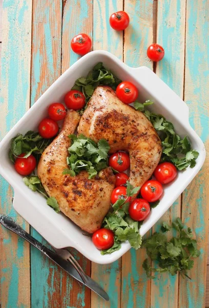 Baked chicken quarter with cherry tomatoes. Roast chicken quarter with the addition of cherry tomatoes. Selective focus