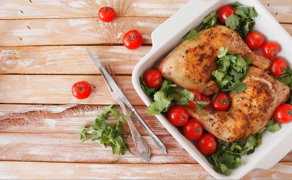 Baked chicken quarter with cherry tomatoes. Roast chicken quarter with the addition of cherry tomatoes. Selective focus