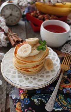 Beyaz bir plaka üzerinde bir kahvaltıda muzlu pankek. Rustik tarzı.