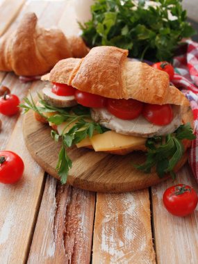 Pastırma, peynir, marul ve domates beyaz tahta masada kruvasan sandviç. Sağlıklı snack.