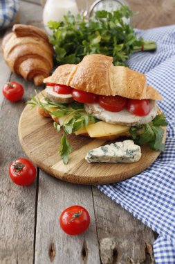 Pastırma, peynir, marul ve domates beyaz tahta masada kruvasan sandviç. Sağlıklı snack.