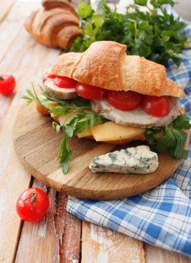 Pastırma, peynir, marul ve domates beyaz tahta masada kruvasan sandviç. Sağlıklı snack.