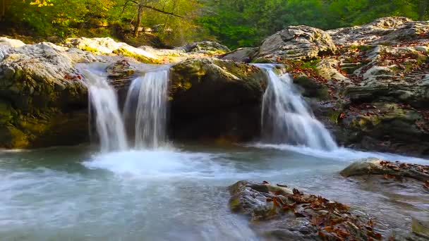 Un río fluye sobre rocas en esta hermosa escena en las montañas en otoño — Vídeo de stock