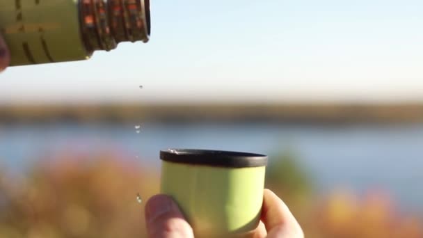 Un uomo versa il tè da una bottiglia di thermos — Video Stock